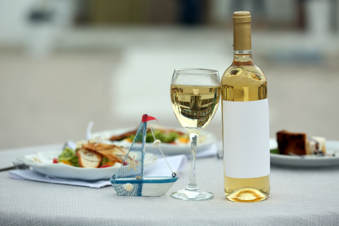 Bottle of Luxury Wine with Tasty Salad on White Table